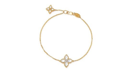 A dainty gold chain bracelet featuring two four-petaled flower pendants filled with mother of pearl
