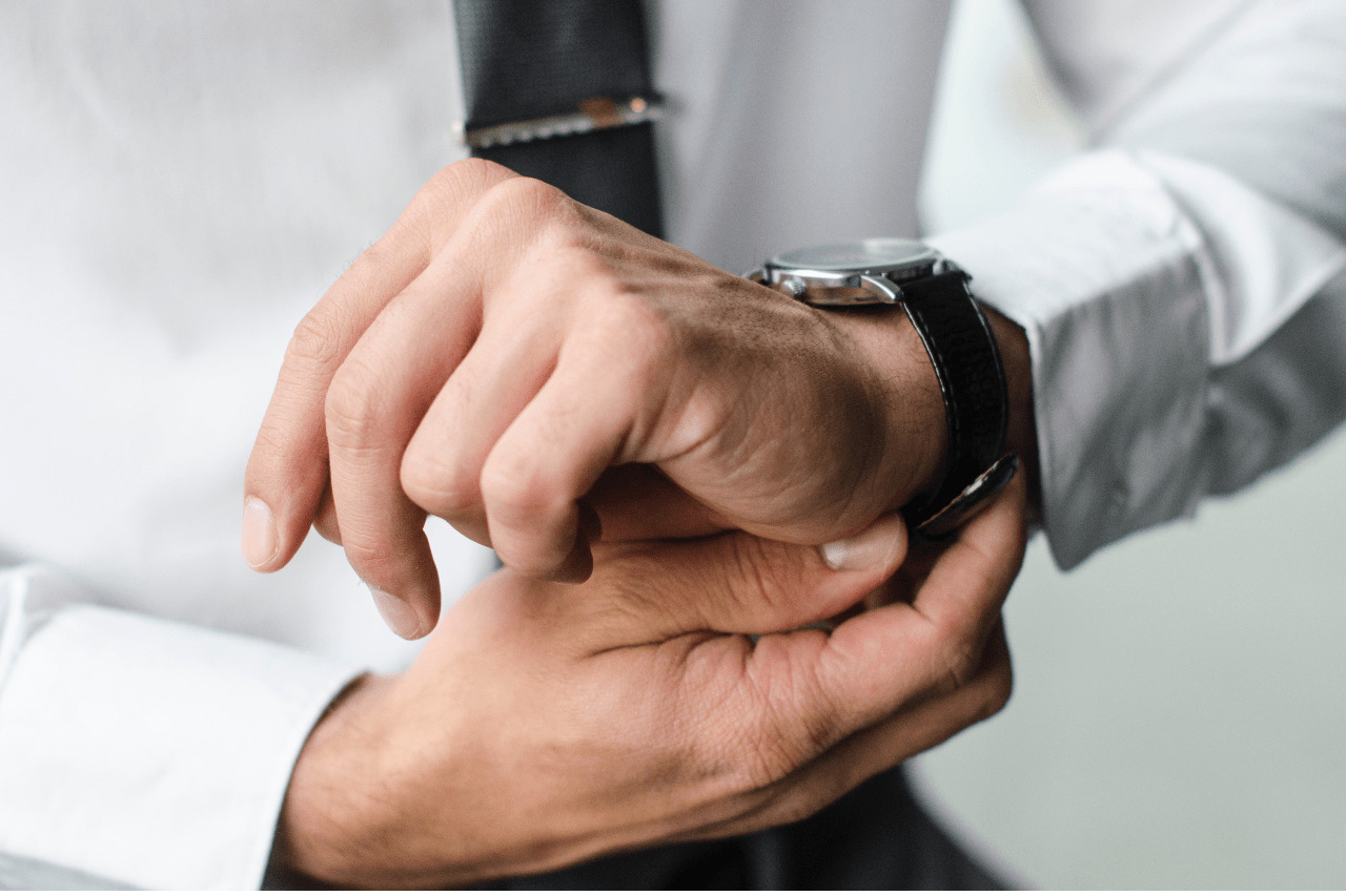 A man getting ready for the day puts on a watch