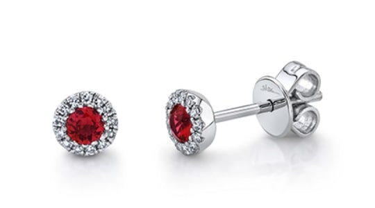 A pair of ruby stud earrings with diamond halos from Shy Creation.