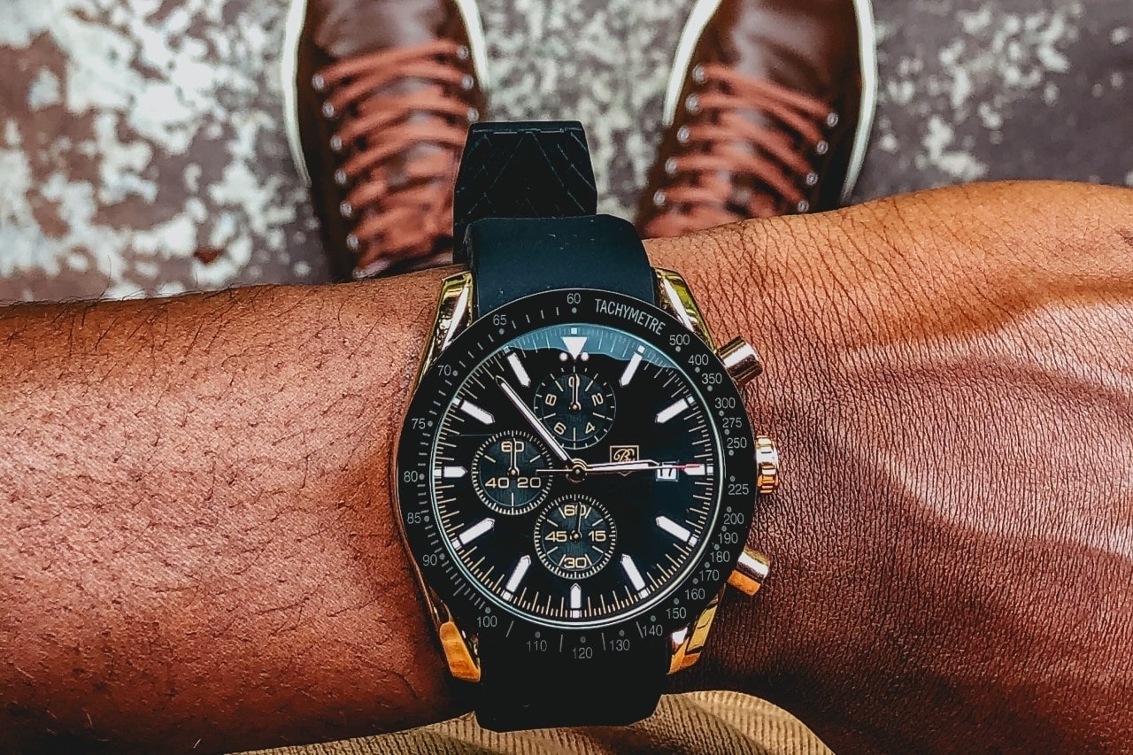 a man’s wrist wearing a black Breitling timepiece