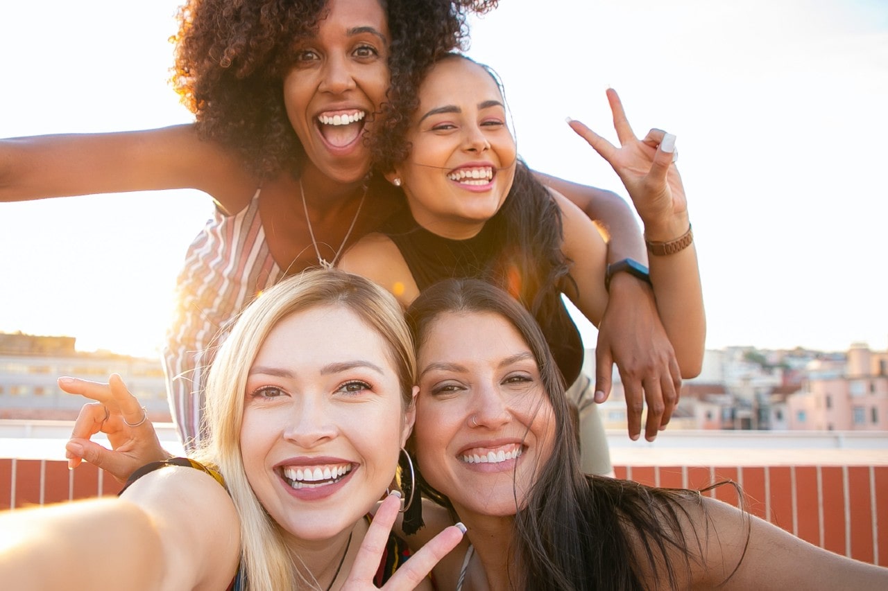 four women smiling and posing for a photo