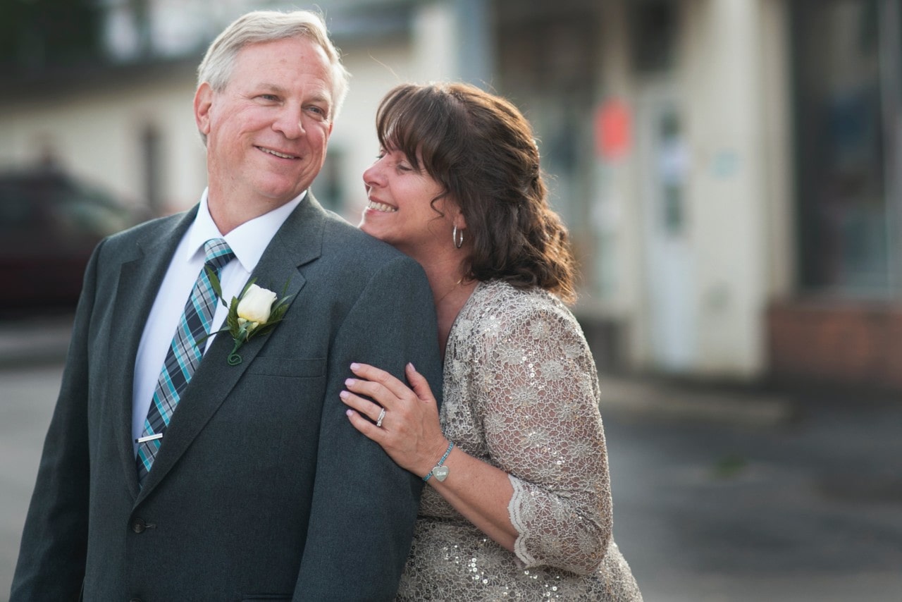 An older couple embraces at a formal event.