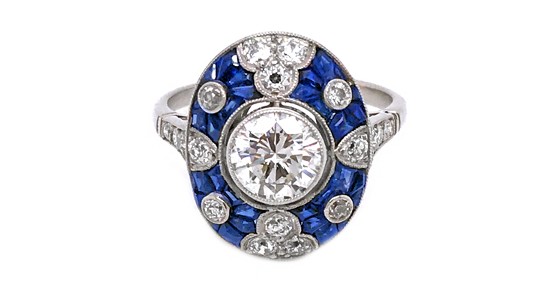 a platinum cocktail ring featuring and oval shape set with diamonds and sapphires