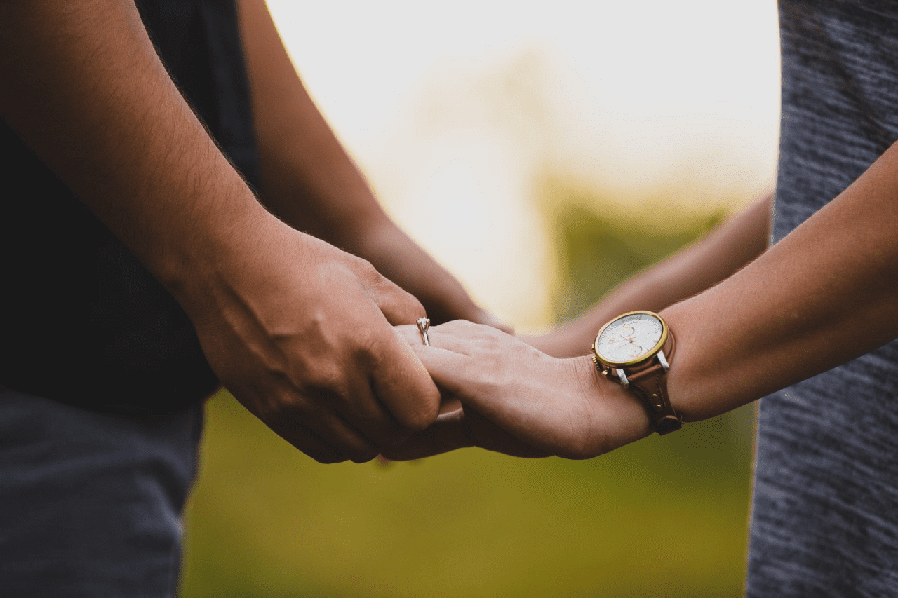 a woman wearing a fine watch and holding hands with a man