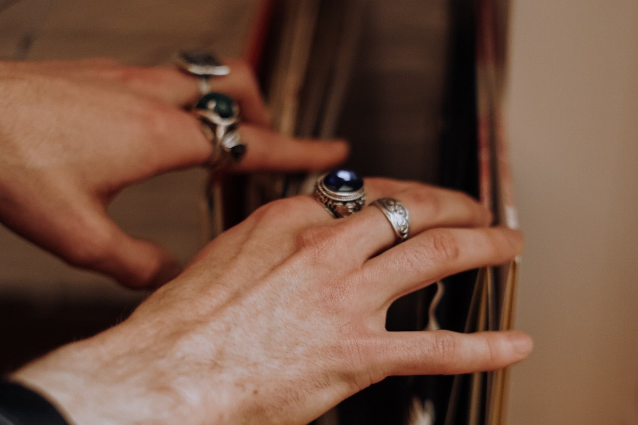 someone looking through a leather portfolio and wearing a number of silver fashion rings.