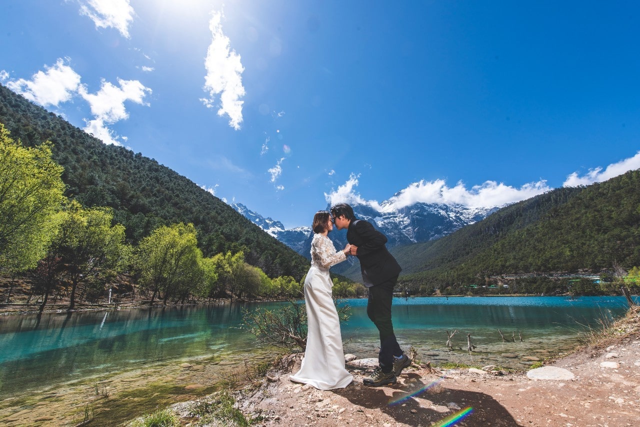 a married couple embracing in front of a scenic backdrop